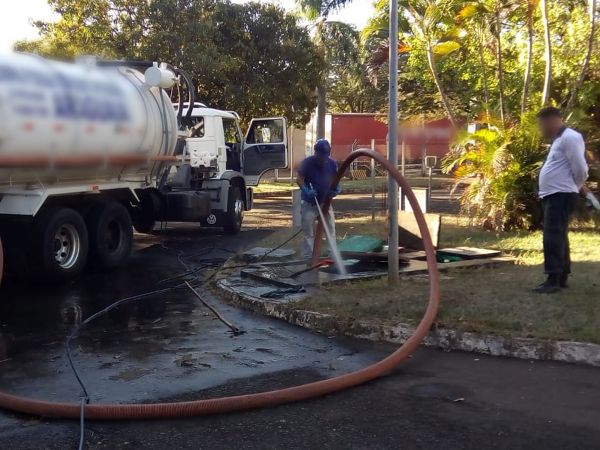 Técnico operando equipamento de hidrojateamento ligado a caminhão especializado