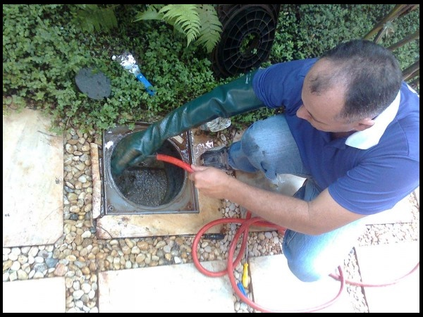 Técnico fazendo manutenção preventiva em tubulações de cozinha profissional