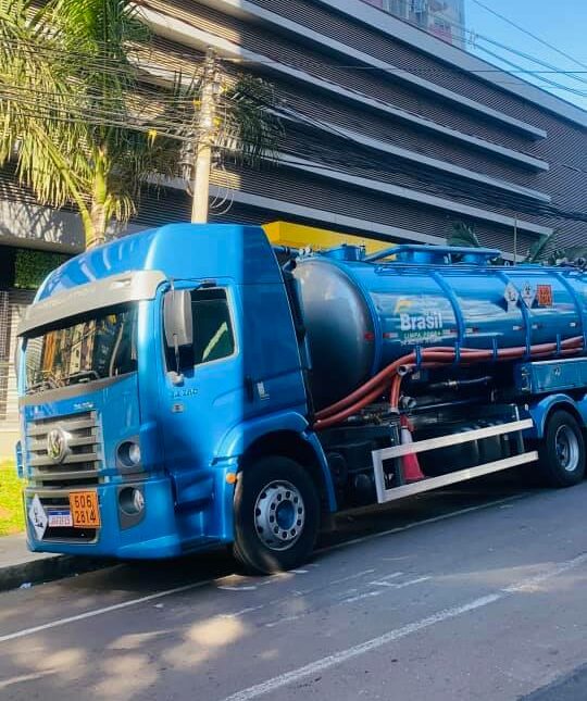Técnico realizando desentupimento na área externa de um condomínio